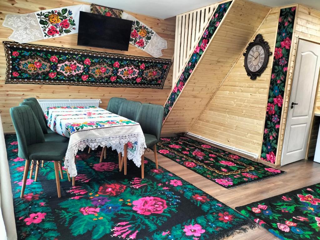 a room with a table and chairs and a clock at A frame Sima in Breb
