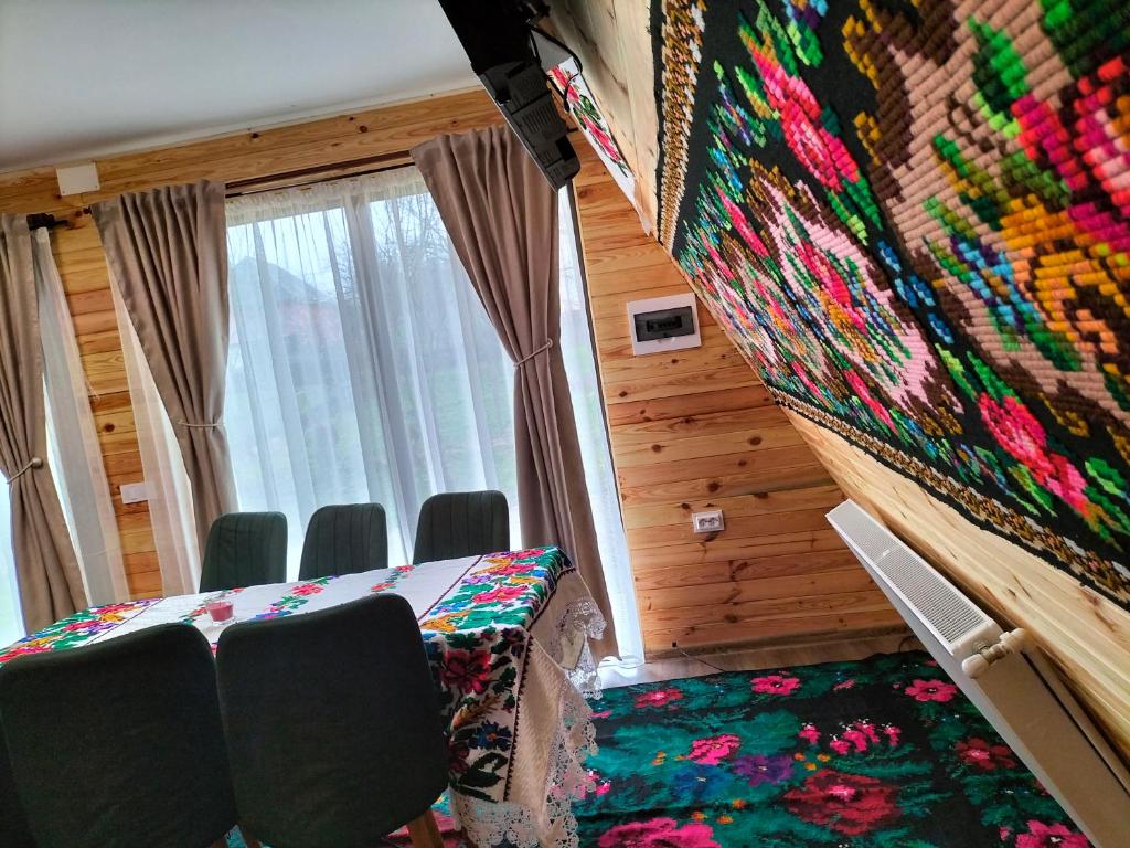 a room with a bed and chairs and a wall with a blanket at A frame Sima in Breb