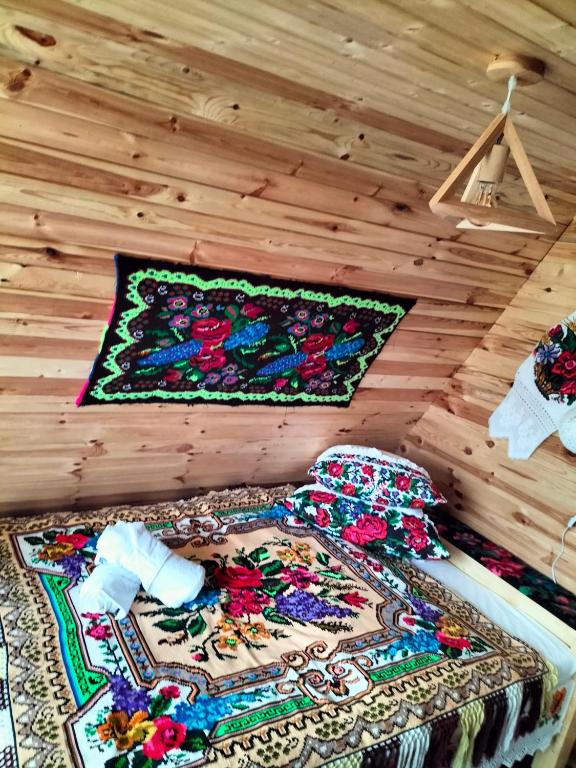 a bed in a room with a rug on the wall at A frame Sima in Breb