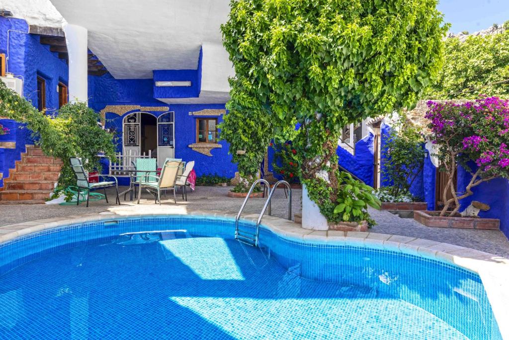 ベナオカスにある5 bedrooms villa with private pool furnished terrace and wifi at Benaocazの青い家の前のスイミングプール