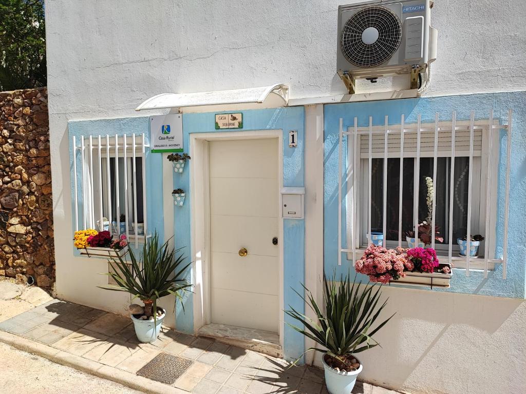 ein blaues Gebäude mit einer Tür und zwei Fenstern in der Unterkunft Casa Iribarne in Rodalquilar