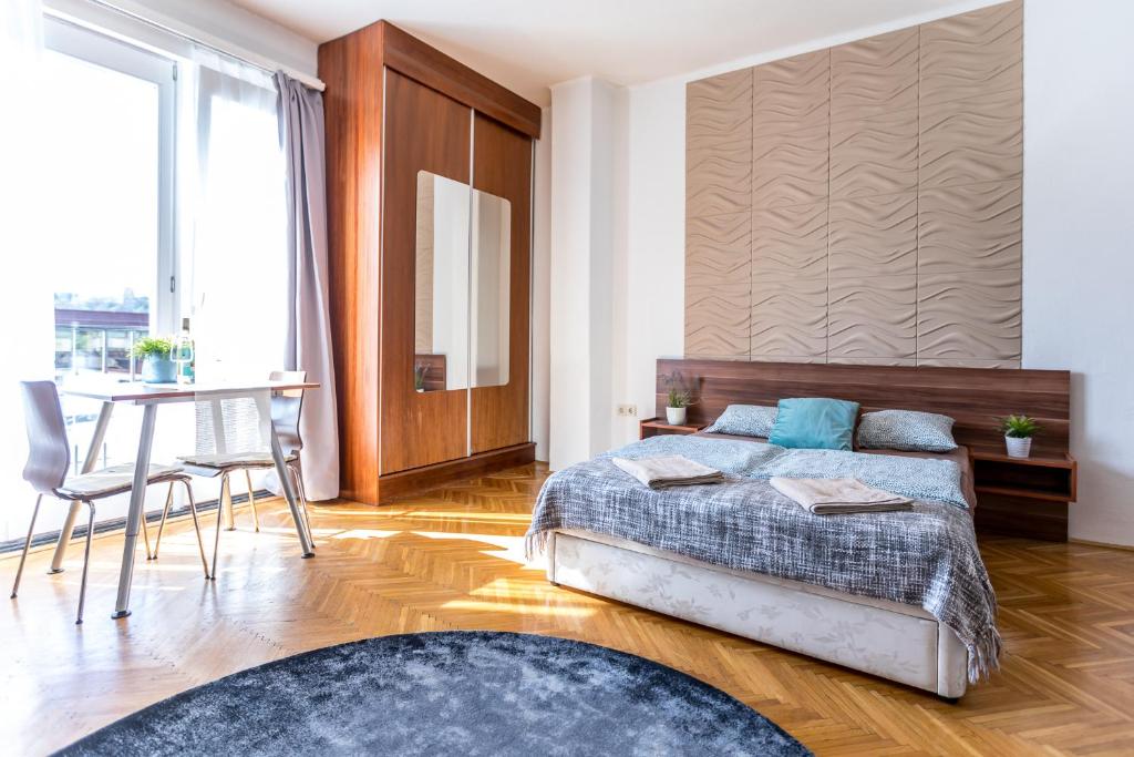 a bedroom with a bed and a table and a desk at Danube Apartment in Budapest