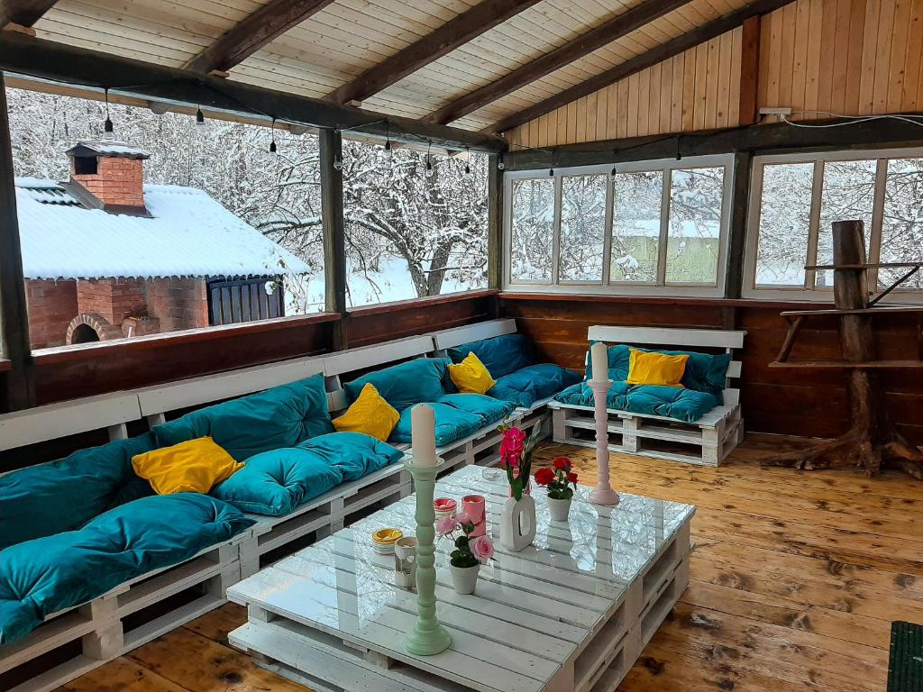 Casa Ele في Frăsinet: غرفة معيشة مع أريكة زرقاء وطاولة