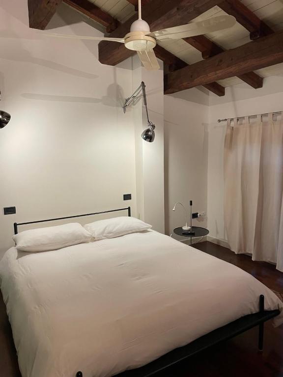 a bedroom with a white bed and a ceiling at Via Braschi Sessantasei in Cesena