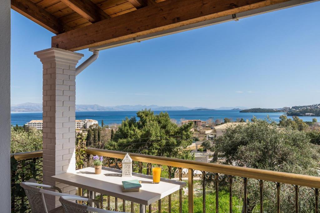 d'un balcon avec une table et une vue sur l'océan. dans l'établissement Aloe Seaview Apartments by Konnect, 500m from Dassia Beach, à Dassia