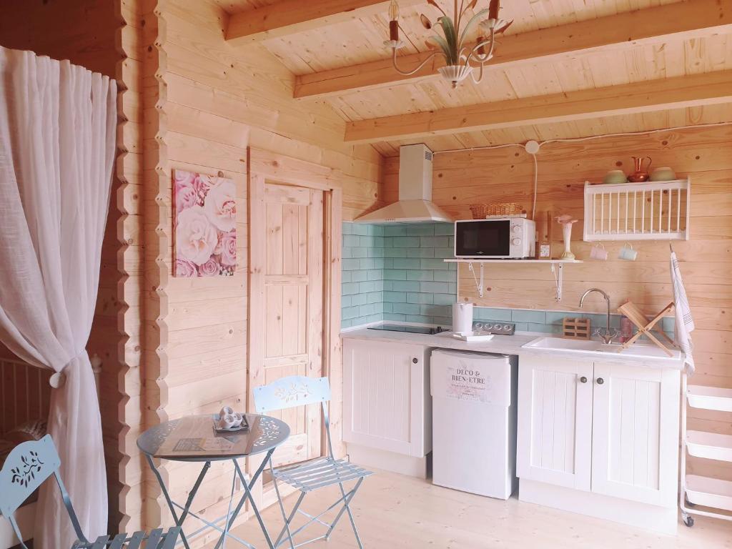 - une cuisine équipée d'un réfrigérateur et d'une table dans une cabine dans l'établissement Le Cottage OneHeart, à Saverne