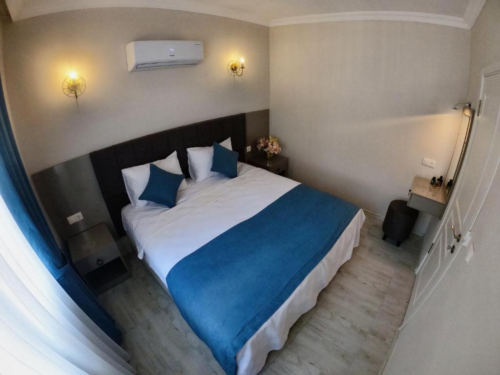 a bedroom with a large bed with blue pillows at MirAlya Homes in Fethiye