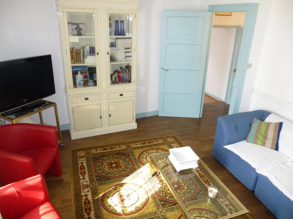salon z niebieską kanapą i telewizorem w obiekcie La rouartiniere w mieście Mignaloux-Beauvoir