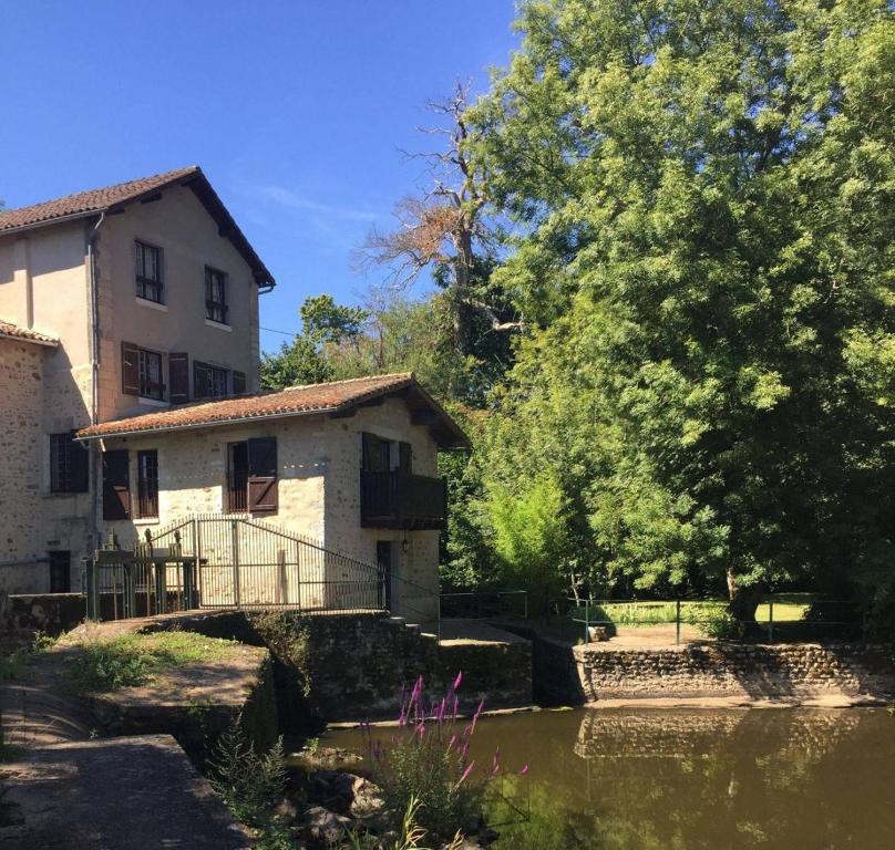 een gebouw naast een rivier met een huis bij Le moulin de l'anglee in Sanxay