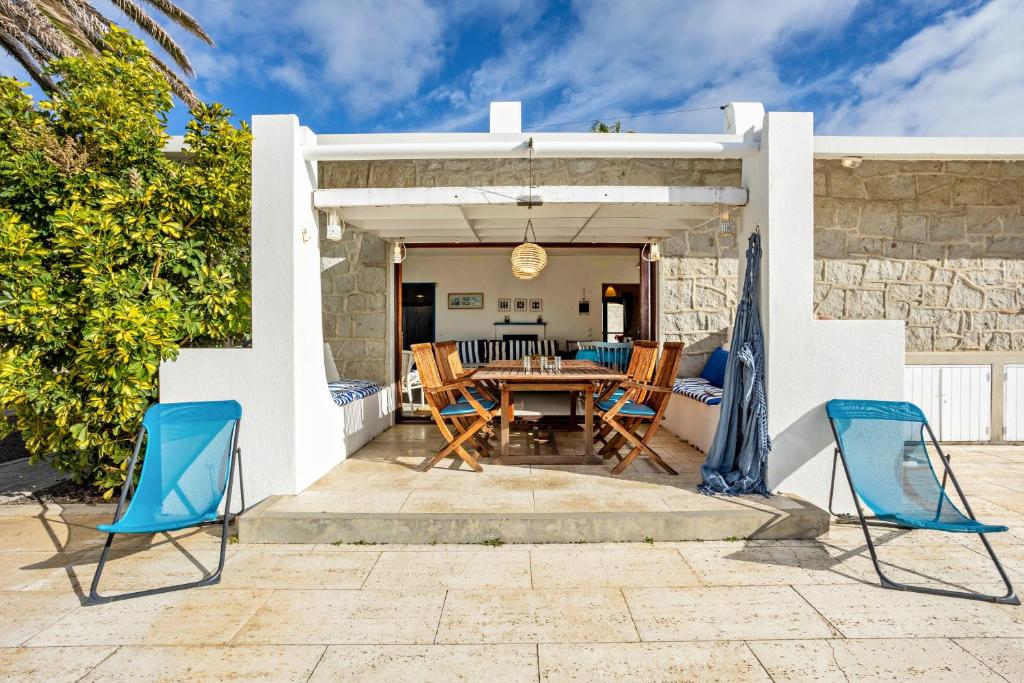 a patio with a wooden table and chairs at Casa da Praia in Vila Baleira