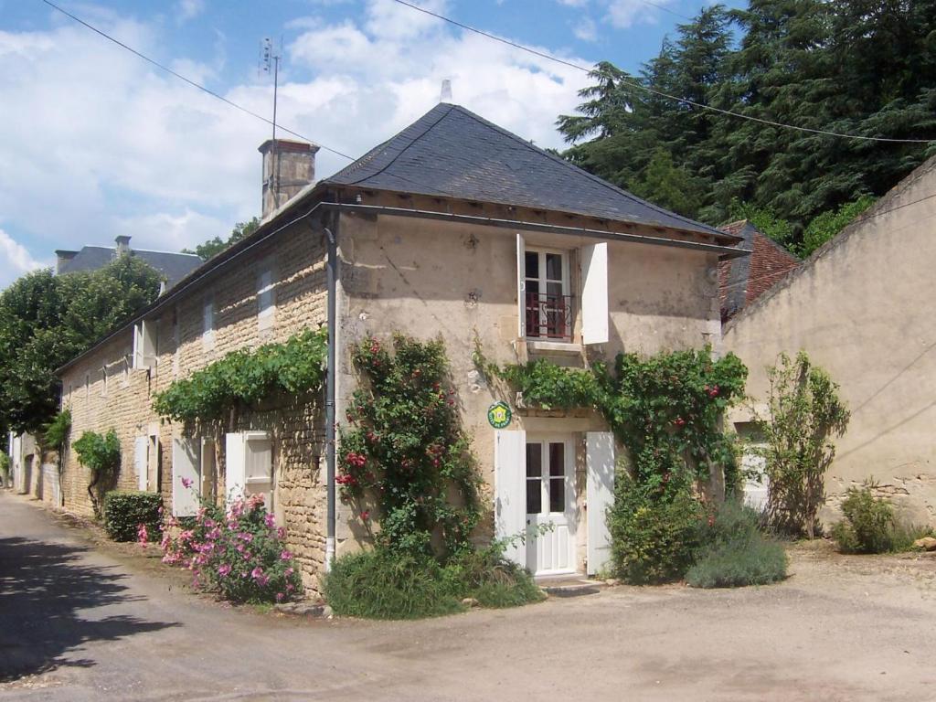un vecchio edificio in mattoni con fiori e piante sopra di La maison du fermier a Chauvigny
