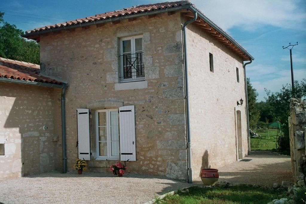 um grande edifício de pedra com uma janela e uma porta em Le figuier em Chauvigny