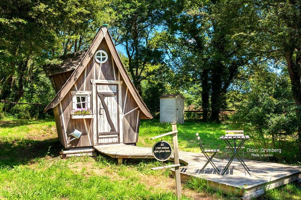 a small house with a sign in the grass at Dihan Evasion in Ploemel