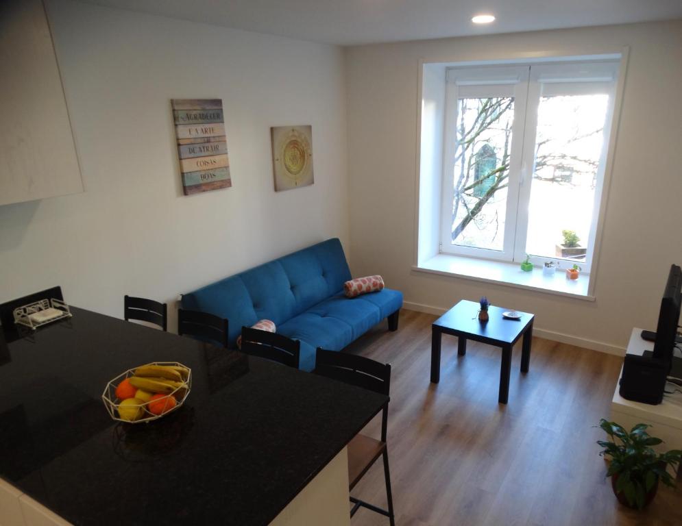 - un salon avec un canapé bleu et une table dans l'établissement Casa da Barca, à Ponte da Barca