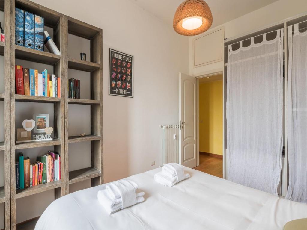 a bedroom with a white bed and book shelves at The Best Rent - Colourful two-bedroom apartment near Termini Station in Rome