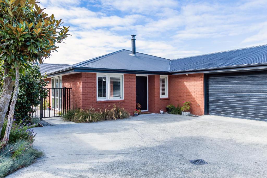 a red brick house with a garage at Contemporary Methven Abode in Methven