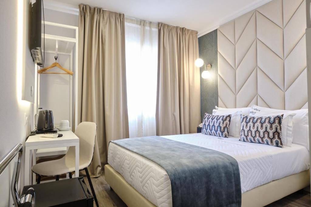 Patria Hotel في لشبونة: غرفة نوم بسرير ومكتب ونافذة