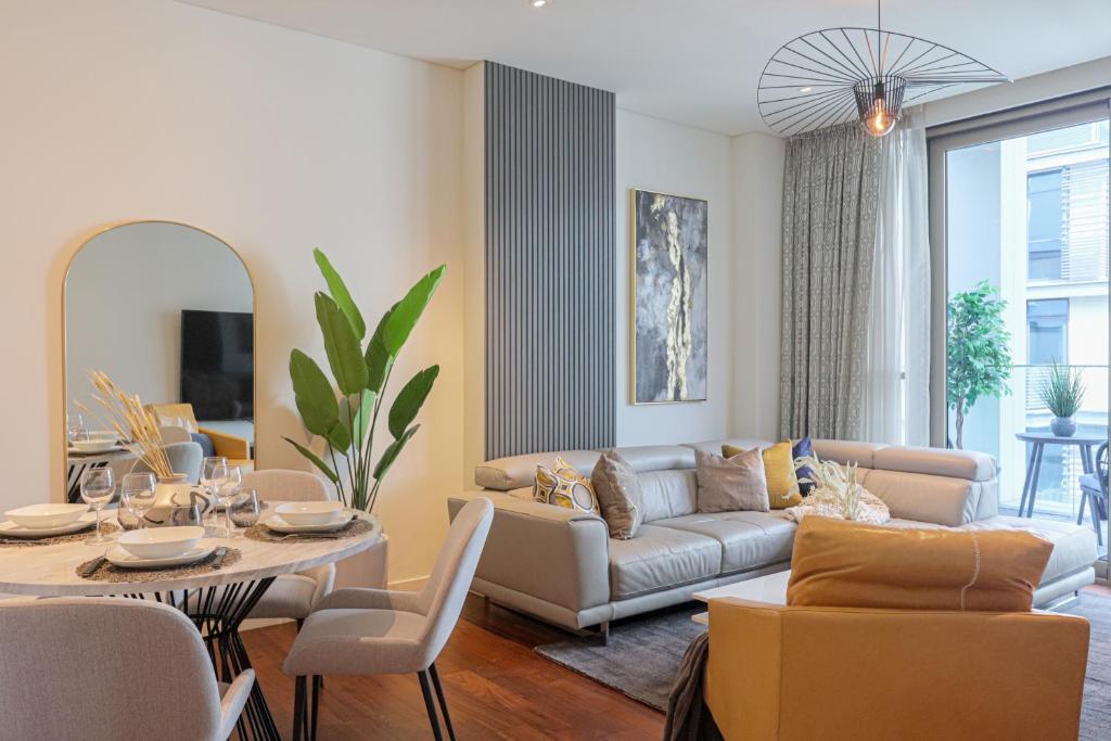 a living room with a couch and a table at HiGuests - Charming Retreat in CityWalk With Balcony and Pool in Dubai