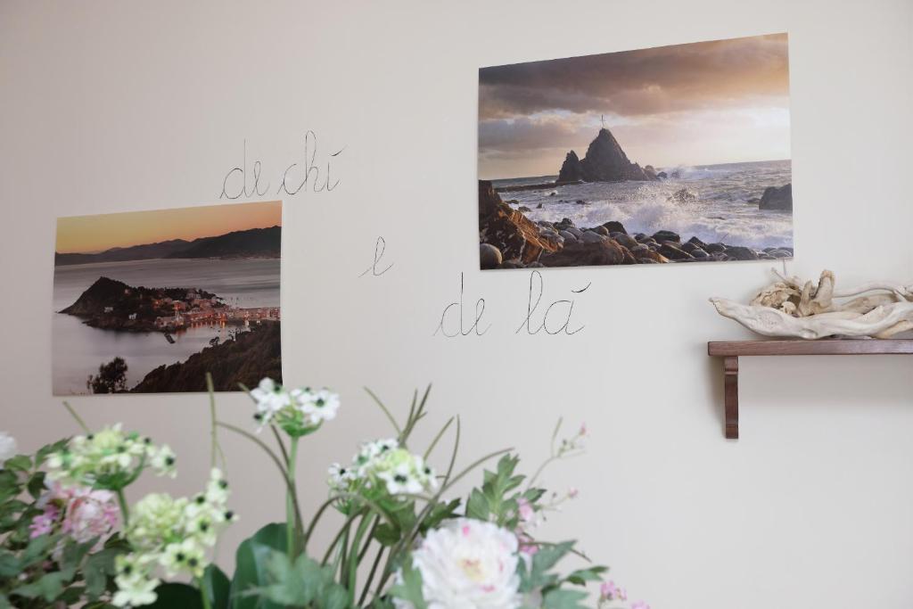 dois quadros pendurados numa parede branca com flores em De chì e de là em Sestri Levante