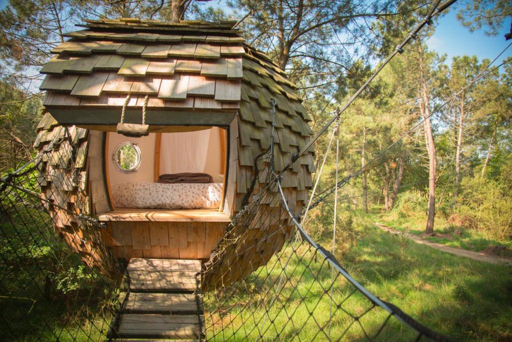 a bed in a tree house in a field at Dihan Evasion in Ploemel