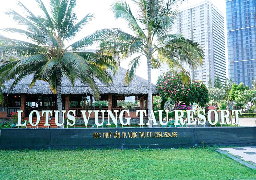 a sign for a louis wing tulum resort with palm trees at Lotus Vung Tau Resort & Spa in Vung Tau