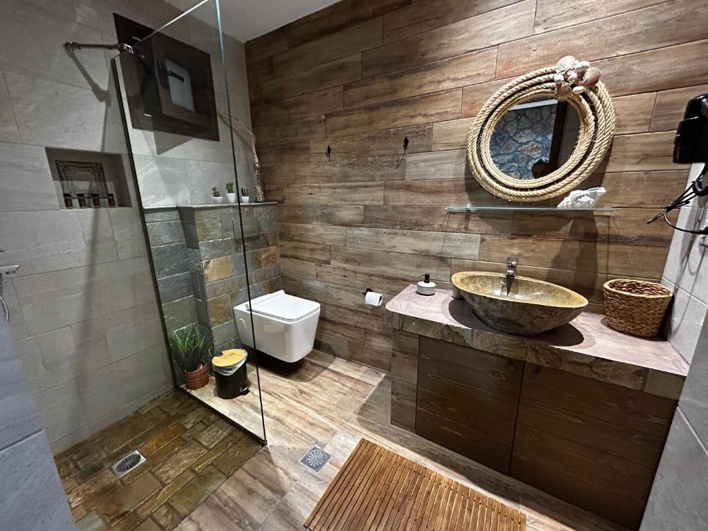ein Badezimmer mit einem Waschbecken, einem WC und einem Spiegel in der Unterkunft Aithonas Villa in Archangelos