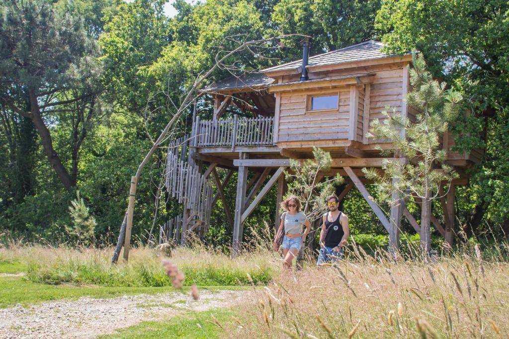 two children standing in front of a tree house at Dihan Evasion in Ploemel