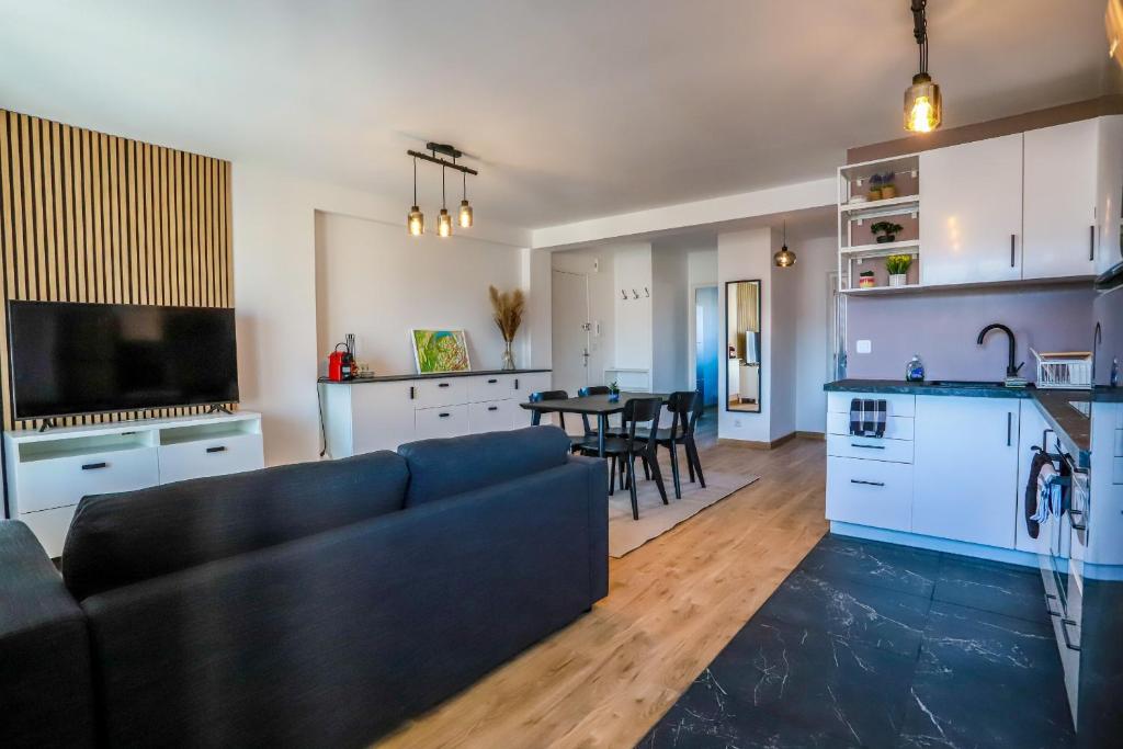 sala de estar y cocina con sofá y mesa en Les Fins Nord, appartement 2 étoiles confortable a Annecy, en Annecy