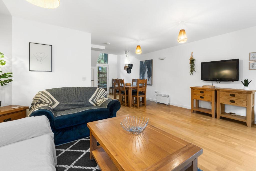 ein Wohnzimmer mit einem Sofa und einem Tisch in der Unterkunft House 5 Ironcroft - Modern Pet-friendly & hot tub, Walk to beach & village in Porthtowan