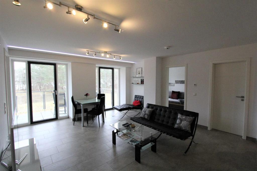 ein Wohnzimmer mit einem Sofa und einem Tisch in der Unterkunft Strandresidenz Appartement Haubentaucher G22 in Binz