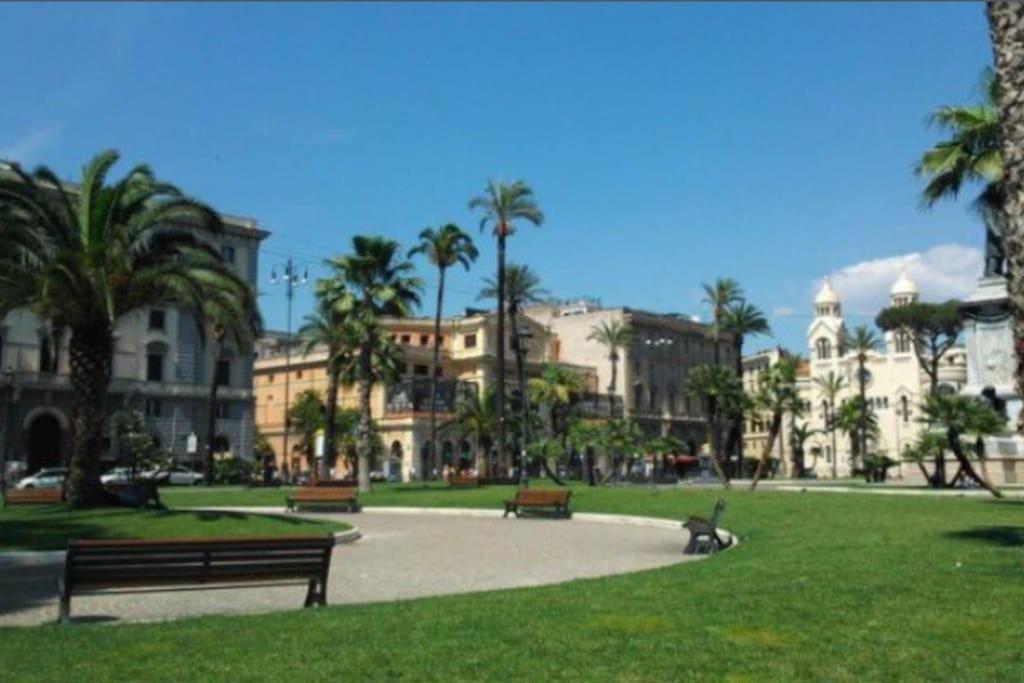 einen Park mit Bänken, Palmen und Gebäuden in der Unterkunft Casa Benso - near Vatican City and Navona Square in Rom