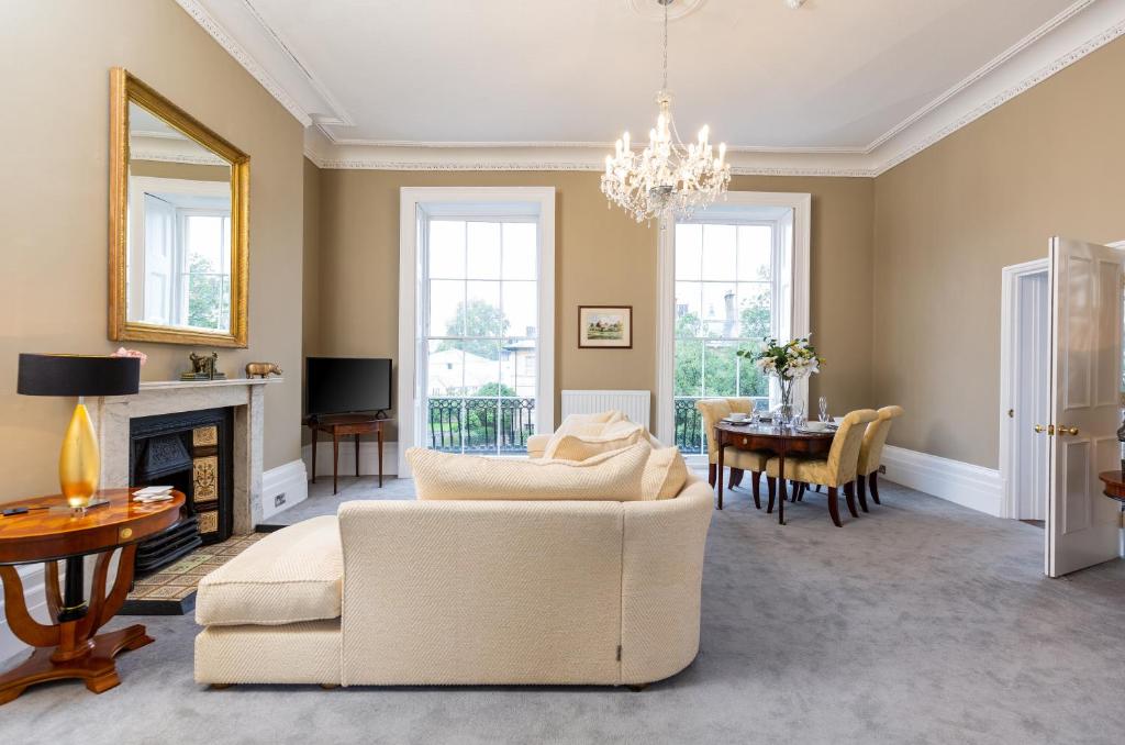 a living room with a white couch and a table at Elizabeth House Flat 2 in Cheltenham