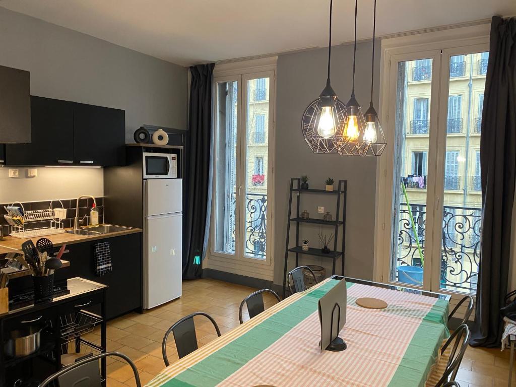 - une cuisine et une salle à manger avec une table et des chaises dans l'établissement La Plénitude Marseillaise - T4 de 70 m2, 3 chambres, centre-ville, 8 couchages, à Marseille
