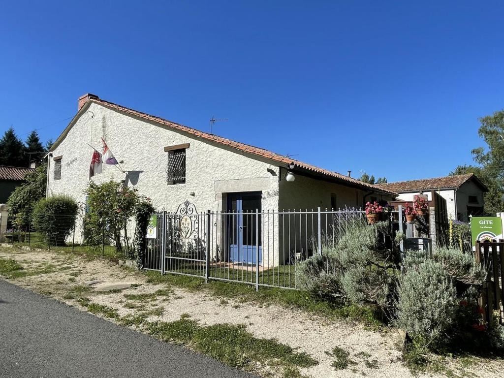 a white house with a fence in front of it at Le balét in Asnois