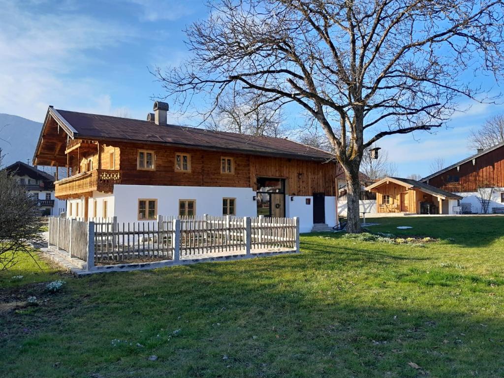 drewniany dom z płotem i drzewem w obiekcie Geigelstein Chalets w mieście Unterwössen