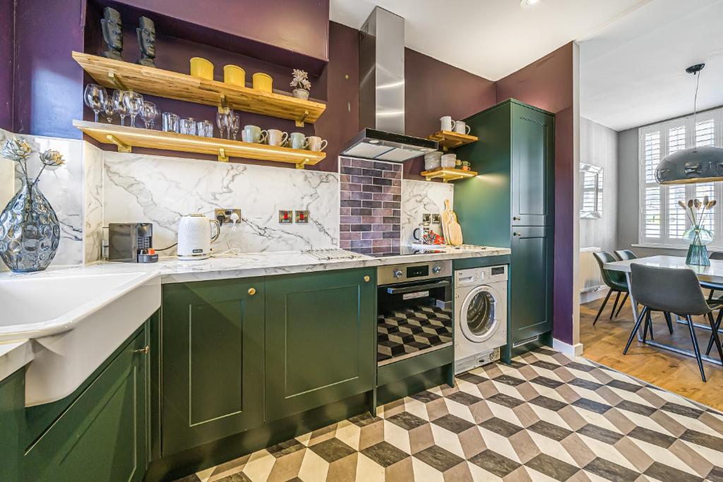 eine Küche mit grünen Schränken und einer Waschmaschine in der Unterkunft Corner Lodge Bishophill York - FREE PARKING in York