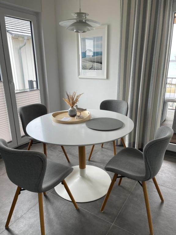 ein Esszimmer mit einem weißen Tisch und Stühlen in der Unterkunft Ferienhaus SEE & Ferienhaus SEEBLICK in Neukieritzsch