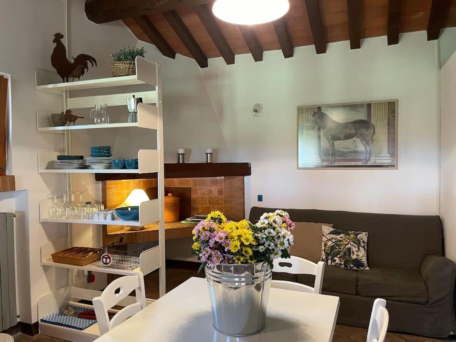 una sala de estar con un jarrón de flores sobre una mesa en I Mandrioli, una casa immersa nella natura., en Casale Marittimo