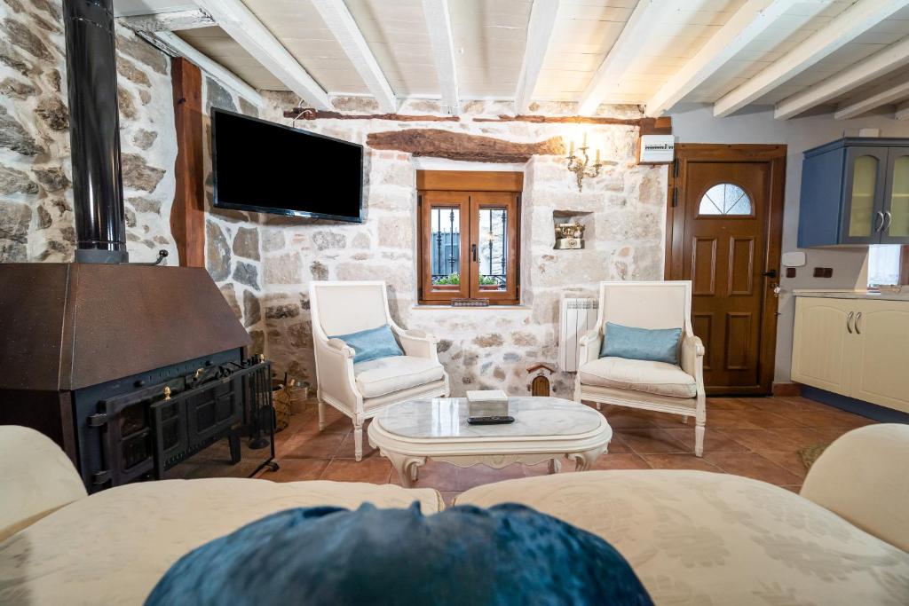 a living room with a fireplace and a stone wall at La Casa del Señor Perez in Bustarviejo