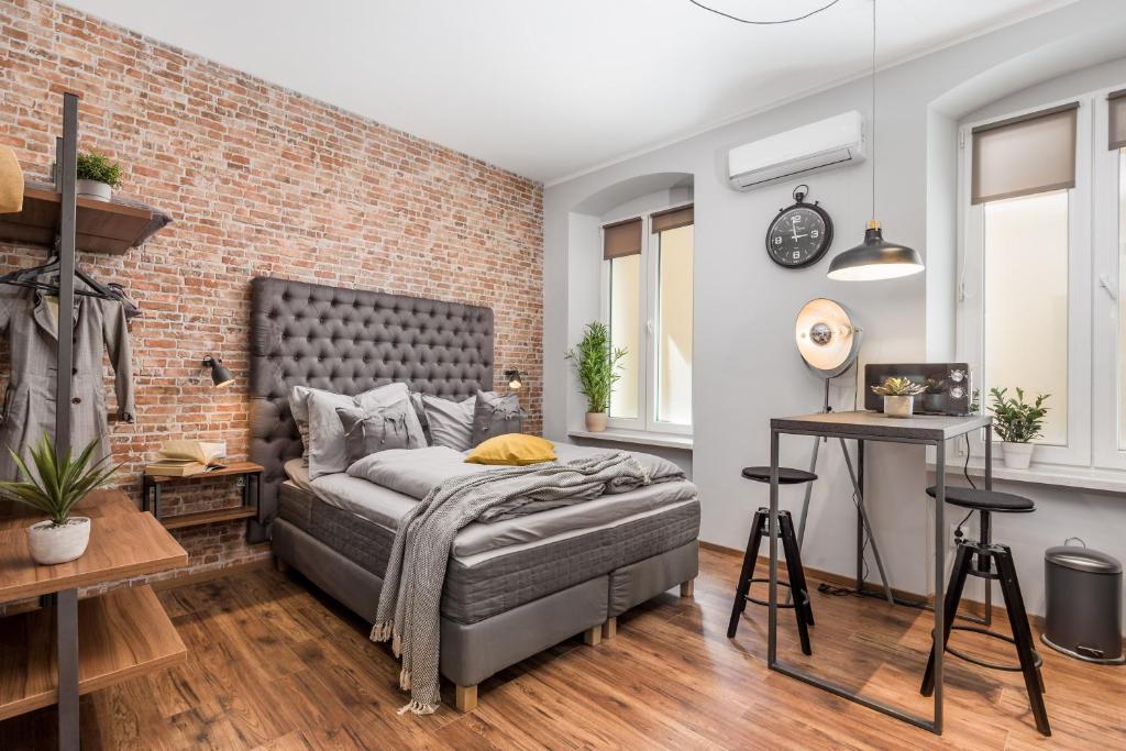 a bedroom with a bed and a brick wall at Apartments Porto Marina 2 in Rijeka