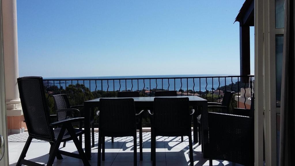 d'une table et de chaises sur un balcon avec vue. dans l'établissement Cap Esterel appart 6 pers vue mer classé 3 etoiles, à Saint-Raphaël