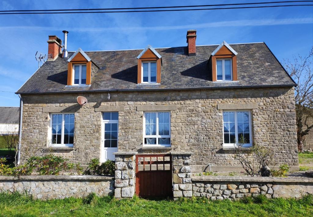 une ancienne maison en pierre avec un toit en ardoise dans l'établissement Potter's Cottage, à Vindefontaine