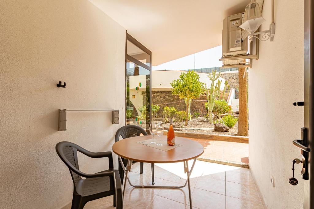 a small table and chairs in a room with a window at SeaBliss Beach of Dunes, Terrace and Pool! in San Bartolomé de Tirajana