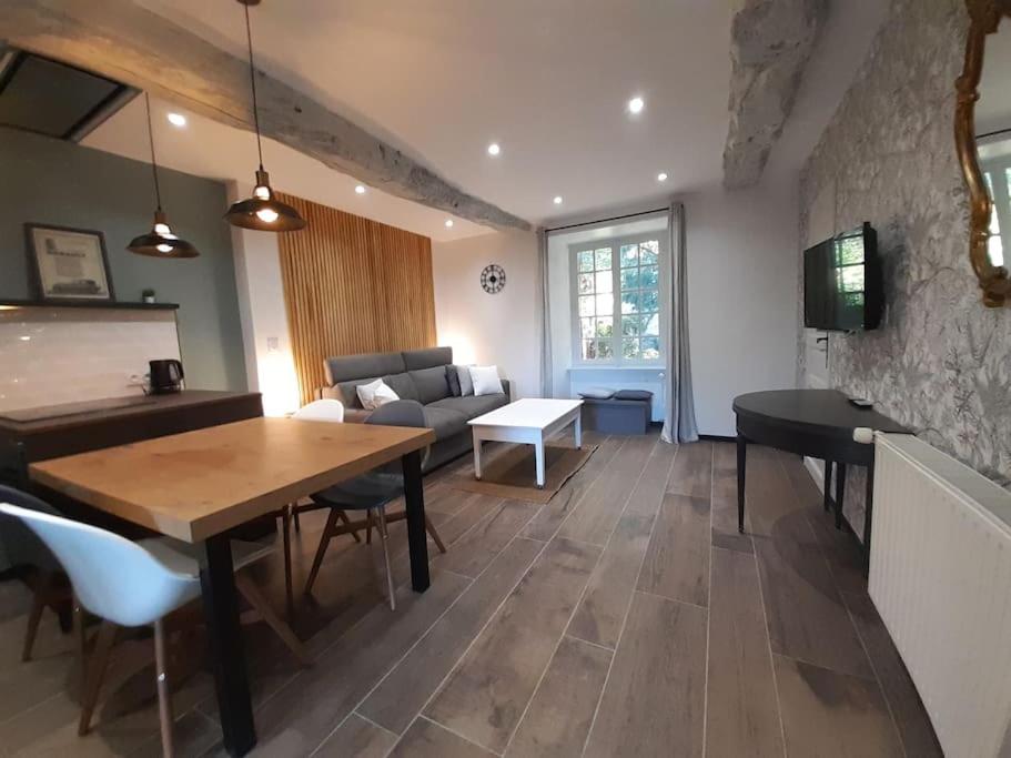 een woonkamer met een tafel en een bank bij Studio meublé avec terrasse axe Rennes Saint Malo in La Baussaine