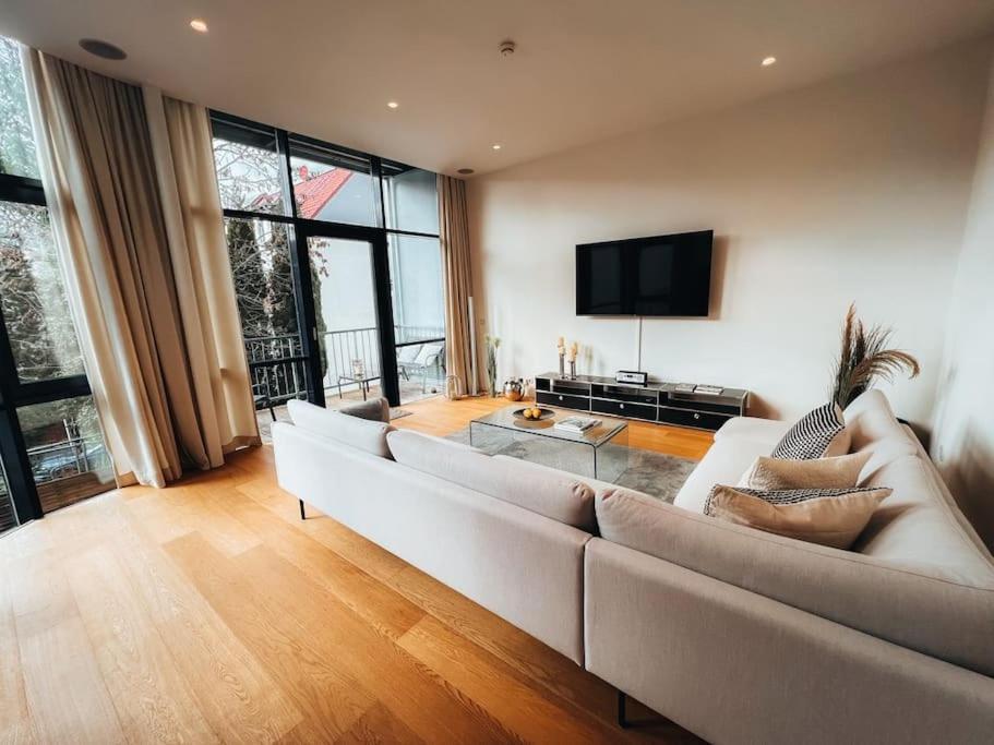ein Wohnzimmer mit einem großen Sofa und einem TV in der Unterkunft Lieblingsapartment No.11 in Toplage mit 2 SZ in Rostock