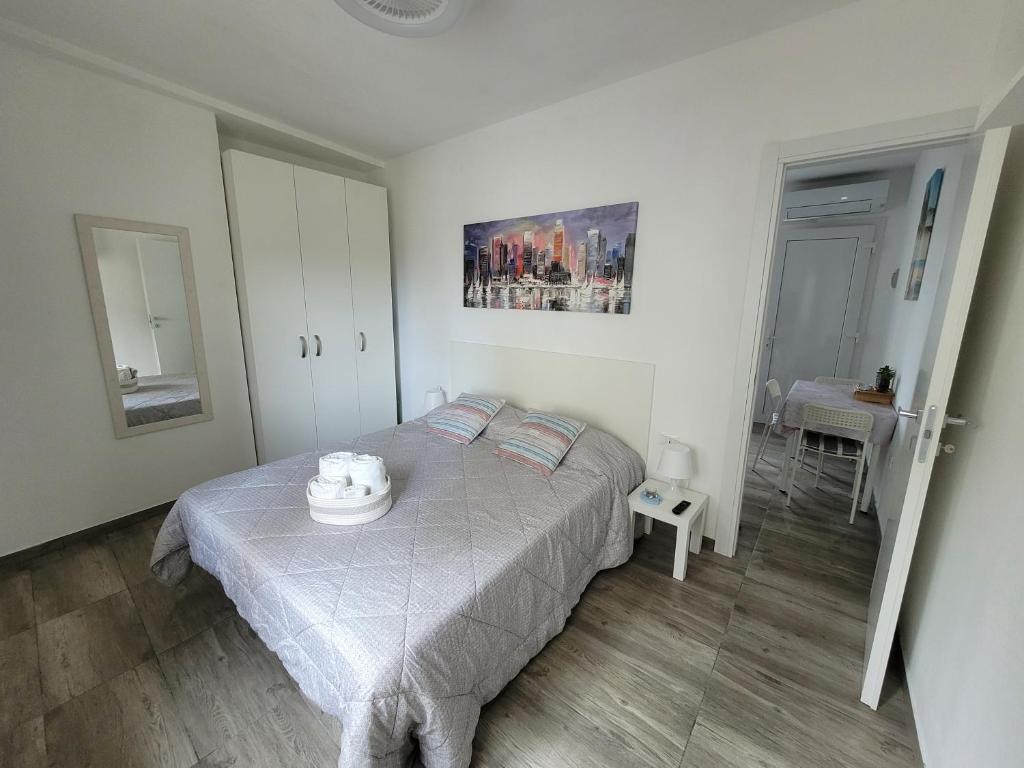 リニャーノ・サッビアドーロにあるArnica Apartmentの白いベッドルーム(ベッド1台、テーブル付)