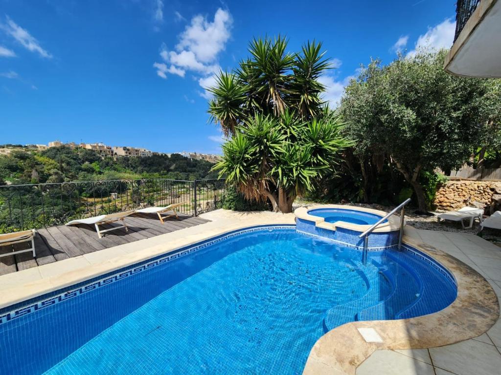 einen Pool in einem Garten mit Bäumen in der Unterkunft Exclusive Pool with your own views with 3 bedrooms and 4 bathrooms in Gozo in Għajn il-Kbira