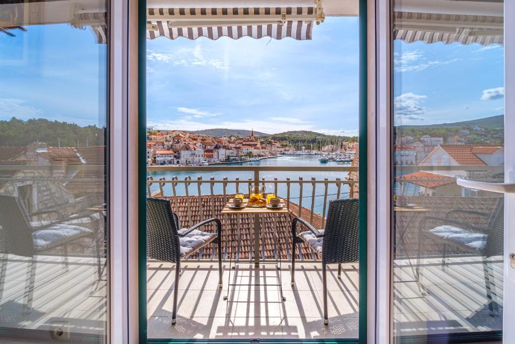 uma vista a partir de uma varanda com uma mesa e cadeiras em Villa Trebotić em Milna
