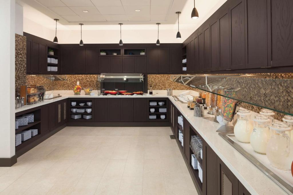 uma cozinha com armários de madeira escura e uma bancada em Hyatt Place Oklahoma City Bricktown em Oklahoma City