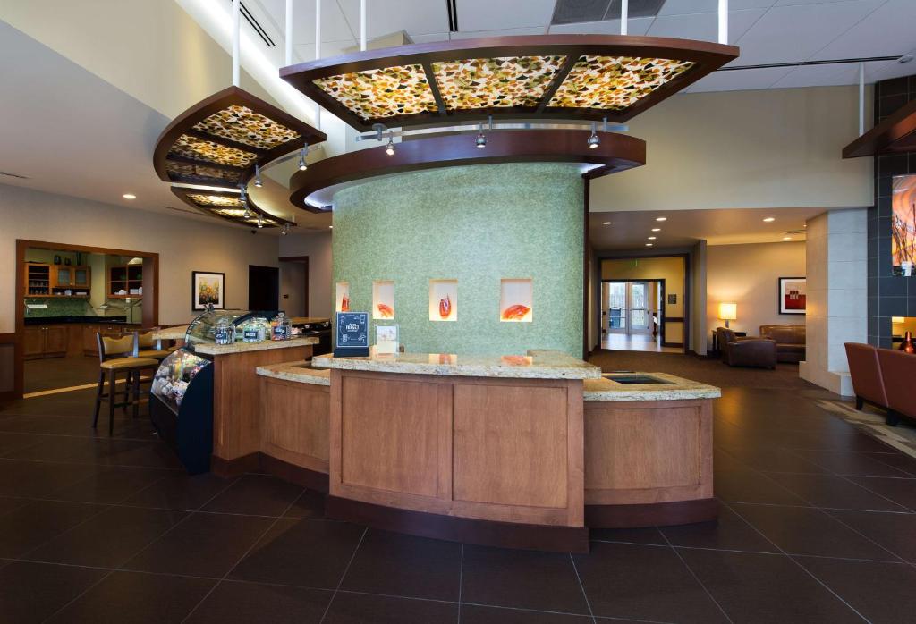 a hotel lobby with a bar in the middle at Hyatt Place Colorado Springs Garden Of The Gods in Colorado Springs